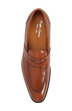 A notched keeper strap enhances the distinctive look of this suave apron-toe loafer crafted of burnished calfskin and finished with hand stitching. Leather upper, lining and sole Made in Italy Designer Shoes Fitted Wingtip Moccasins With Leather Sole, Timeless Moc Toe Loafers, Fitted Leather Moccasins For Semi-formal Occasions, Elegant Cognac Moc Toe Loafers, Elegant Fitted Wingtip Moccasins, Business Wingtip Moccasins, Fitted Leather Sole Plain Toe Moccasins, Fitted Leather Sole Moccasins With Plain Toe, Business Fitted Moccasins With Leather Sole