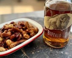 a plate of nuts next to a bottle of beer