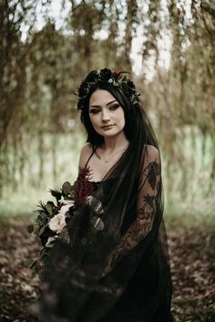 Bride in a black dress looking over her shoulder standing under a tree Goth Bride Hair, Witchy Wedding Hairstyles, Alternative Wedding Makeup, Salem Elopement, Gothic Wedding Hairstyles, Addams Family Themed Wedding, Moody Wedding Makeup, Dark Wedding Makeup