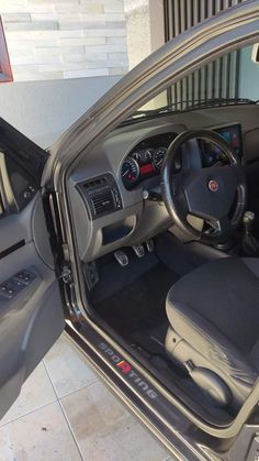 the interior of a car with its door open and steering wheel still in position on the floor