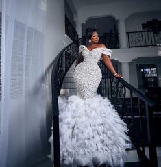 a woman in a white gown standing on stairs