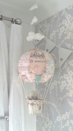 a hot air balloon hanging from the side of a wall next to a shower curtain