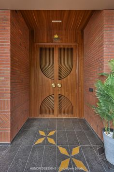 an entrance to a building with a potted plant on the floor and two doors