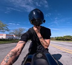 a man riding on the back of a motorcycle down a street