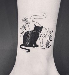 a black and white cat tattoo on the ankle