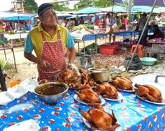 a man standing in front of a table filled with plates of chicken and other foods