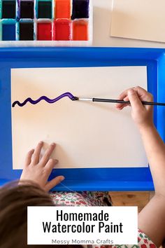 a child is painting with watercolor paint