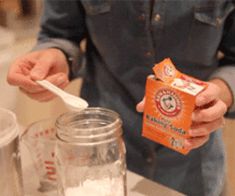 a person standing in front of a blender holding a carton of milk