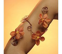 a woman's arm with bracelets and flowers on it