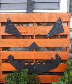 a wooden pallet with some black metal pumpkins on it's face and eyes