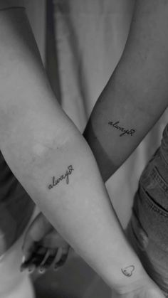 two people holding hands with tattoos on their arms and the words friends written in cursive font