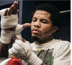 a close up of a person wearing boxing gloves and holding something in his right hand