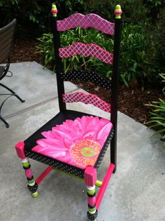 a pink and black chair with a flower on it