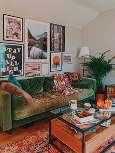 a living room with green couches and pictures on the wall above them, along with a coffee table