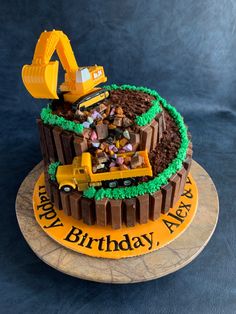 a construction themed birthday cake with chocolate frosting and icing on the top, including an excavator