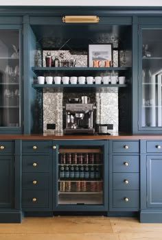 an image of a kitchen with blue cabinets and coffee maker on the top shelf above it