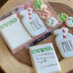 decorated cookies in the shape of milk bottles and candy canes with writing on them