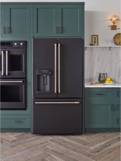 a black refrigerator freezer sitting inside of a kitchen next to green cabinets and counter tops