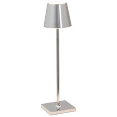 a lamp that is on top of a metal stand with a white light behind it