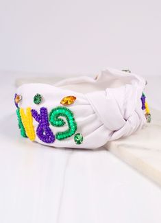 This Mardi Gras fabric headband is decorated with purple, yellow, and green beading with accent gemstones. It has an accent top knot as well. Headband White, Mardi Gras Beads, Purple Decor, Beaded Headband, Fabric Headbands, White Headband, Yellow And Green, Top Knot, Mardi Gras