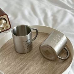 two coffee mugs sitting on top of a tray