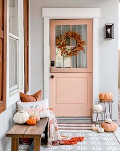 the front door is decorated with pumpkins and other decorations