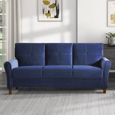 a blue couch sitting in a living room next to a window