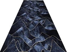 a black and gold rug with mountains in the middle, on a white background that looks like it has been made out of fabric