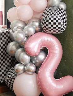 the number two is surrounded by balloons and checkered wallpaper in black, white, and pink