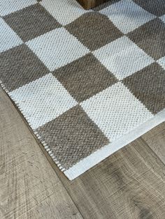 a brown and white rug sitting on top of a wooden floor next to a bed