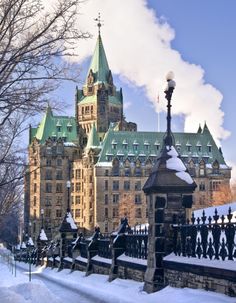 a large building that is next to a fence in the snow