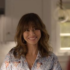 a smiling woman in a blue and white shirt