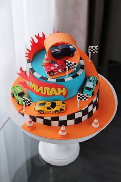 a birthday cake with cars on it sitting on top of a table