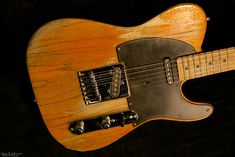 an electric guitar sitting on top of a black surface