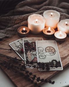 candles and tarot cards on a wooden tray