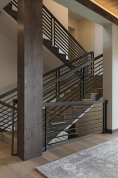 an open staircase in a modern home with wood flooring and metal handrails