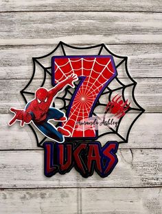 the number seven spiderman is depicted in this sticker on a wooden background with white planks