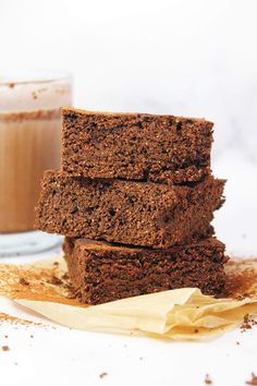 three brownies stacked on top of each other next to a glass of milk and cinnamon