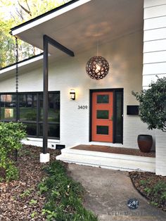 a white house with a red door and black trim