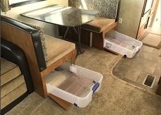 the inside of a travel trailer with two storage bins on each side and a table in the middle