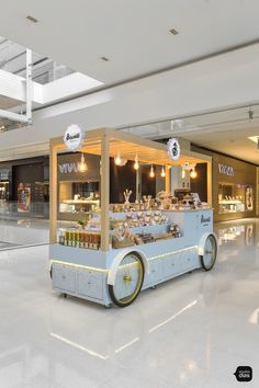 an ice cream cart is in the middle of a shopping mall with lights on it