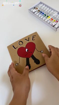 someone is making a love card on a table