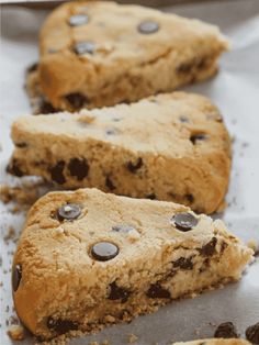 two pieces of chocolate chip cookie sitting on top of white paper with holes in it