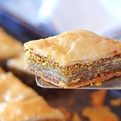 a piece of cake sitting on top of a metal spoon next to other pastries