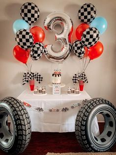 a table with balloons, cake and decorations on it