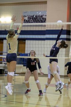 the volleyball players are trying to hit the ball