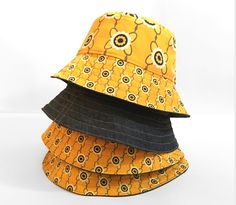 This is the yellow daisy reversible bucket hat giving you two looks in one hat.  Side 1  features a yellow daisy print which has been exclusively designed by myself.  Side 2 is a lightweight mid weight blue denim. It features yellow top stitching and a Stan&Gwyn label on the brim. These hats are very lightweight so easy to pack for holidays or fold up into your pocket at festivals. They also hold their structure due to rows of topstitching on the brim and interfacing.  It's always best if you pr Reversible Yellow Sun Hat For The Beach, Yellow Reversible Sun Hat For Beach, Yellow Reversible Bucket Hat For Beach, Casual Reversible Yellow Bucket Hat, Retro Yellow Bucket Hat For Spring, Adjustable Yellow Reversible Bucket Hat, Adjustable Reversible Yellow Bucket Hat, Casual Yellow Reversible Hat, Trendy Yellow Wide Brim Bucket Hat