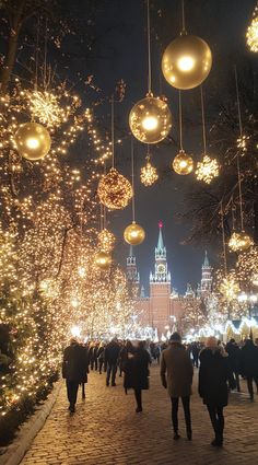 people walking down a street covered in christmas lights