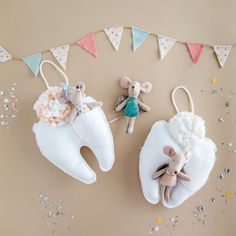 two stuffed animals sitting on top of toothbrushes in front of a bunting banner