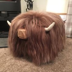 an animal with long hair and horns on the floor